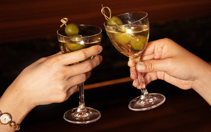 Close-up of hands clinking glasses during festive celebration.