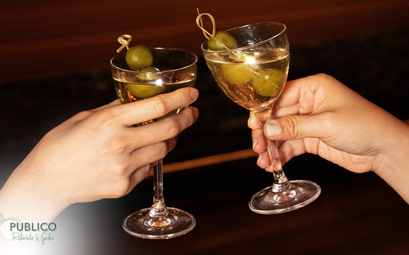 Close-up of hands clinking glasses during festive celebration.