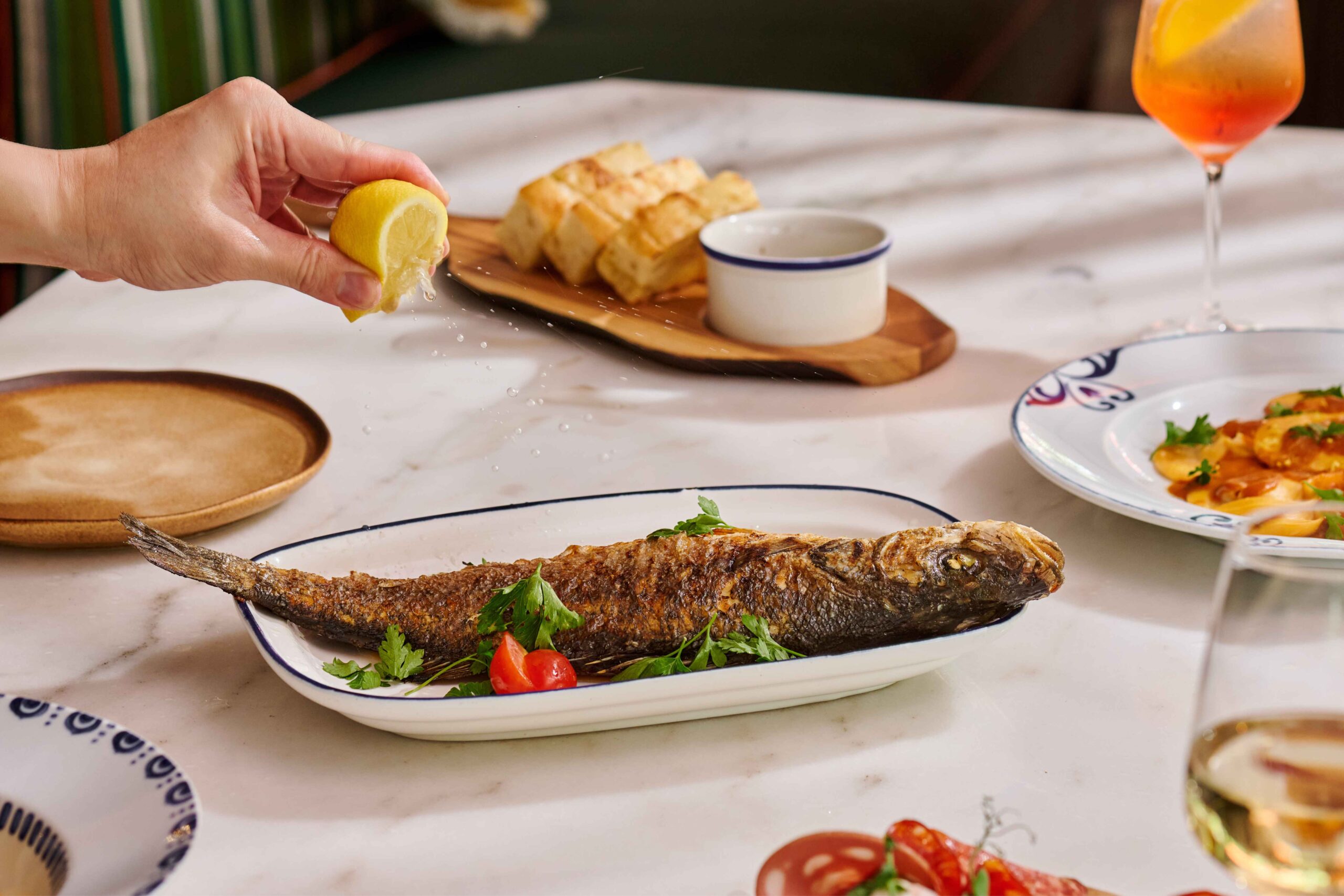 Branzino alla Mediterranea grilled sea bass with olives, cherry tomatoes and potatoes