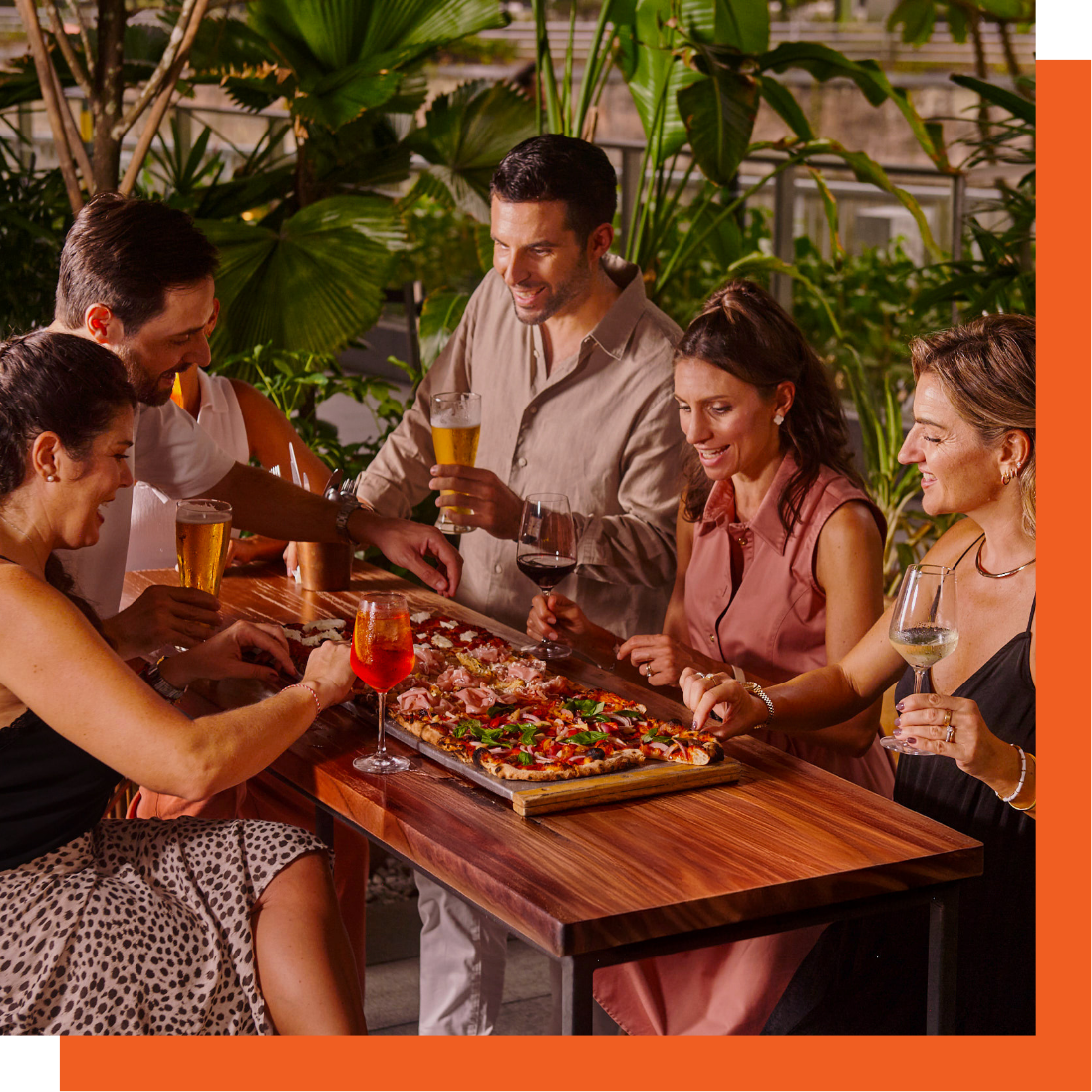 Guests sharing metre-long pizza and drinks at The Pit at Publico
