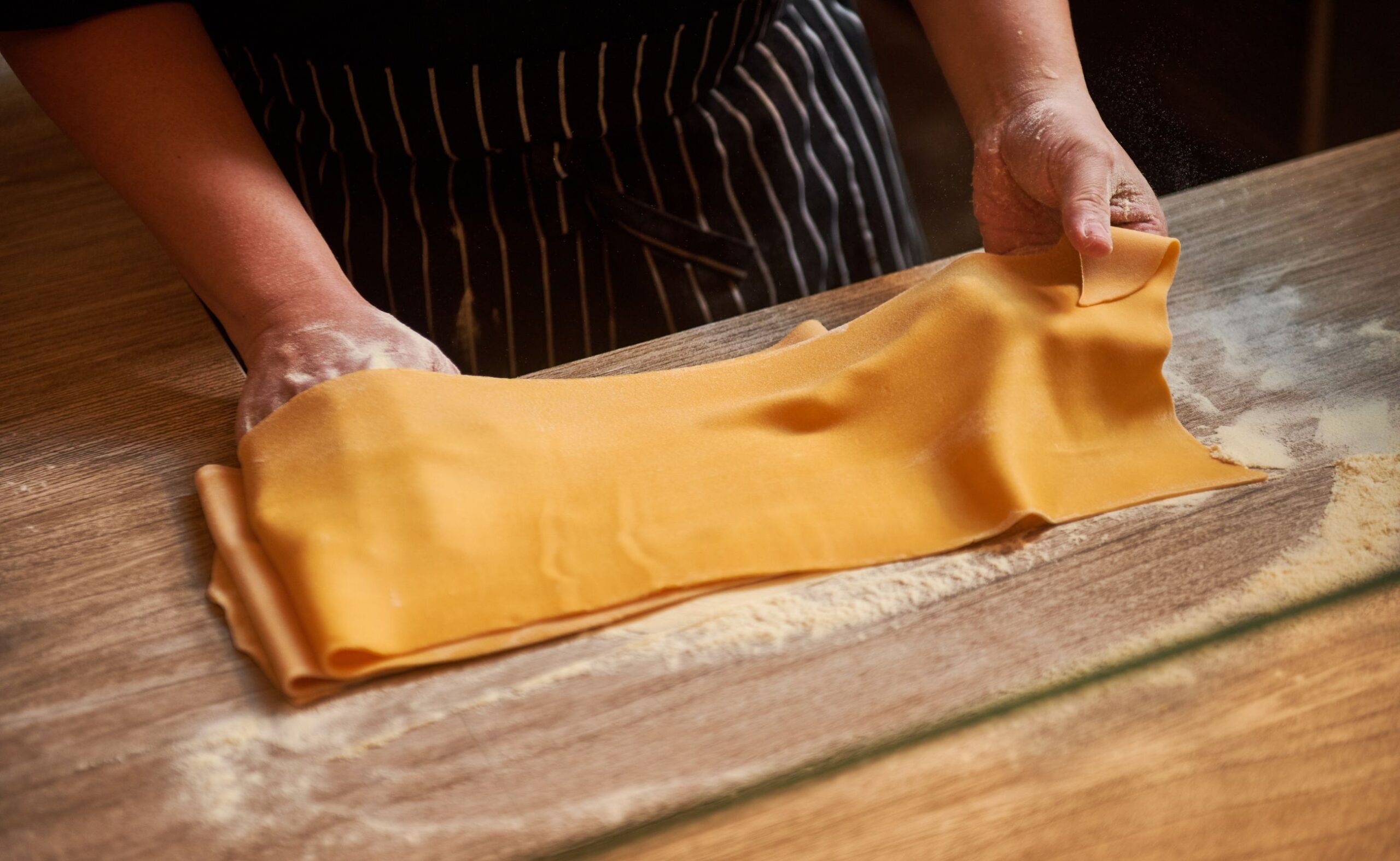 Chef preparing fresh house-made pasta by hand at Publico Ristorante in Robertson Quay, Singapore.