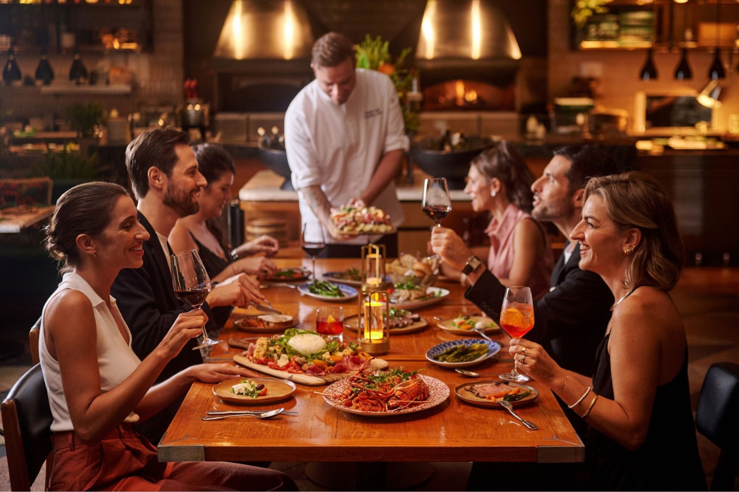 Guests sharing Italian food and wine around a dining table at Publico Ristorante, Robertson Quay, Singapore